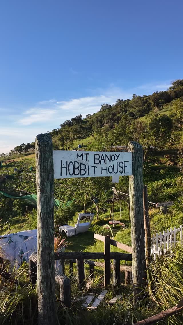 The Mt. Banoy Hobbit House sign on the sun-drenched hillside trail above The Red Hen Homestead, Batangas City